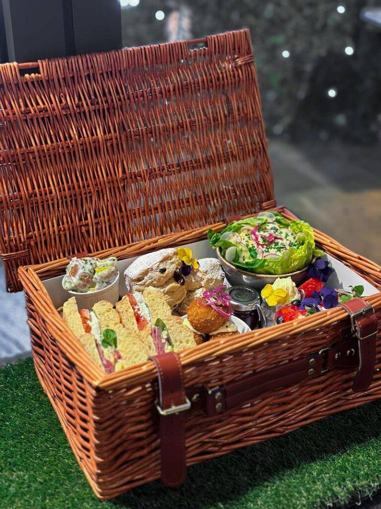 Afternoon tea basket with the lid open showing contents inside