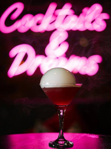 Cocktail in front of neon sign for event